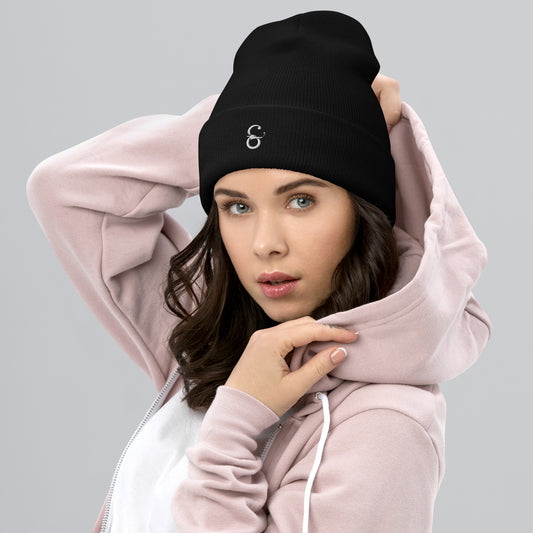 Gorro unisex de punto en color negro con el logo de Símera bordado al frente, modelo femenino mostrando el diseño y como es funcional con sudaderas o abrigos con capucha.