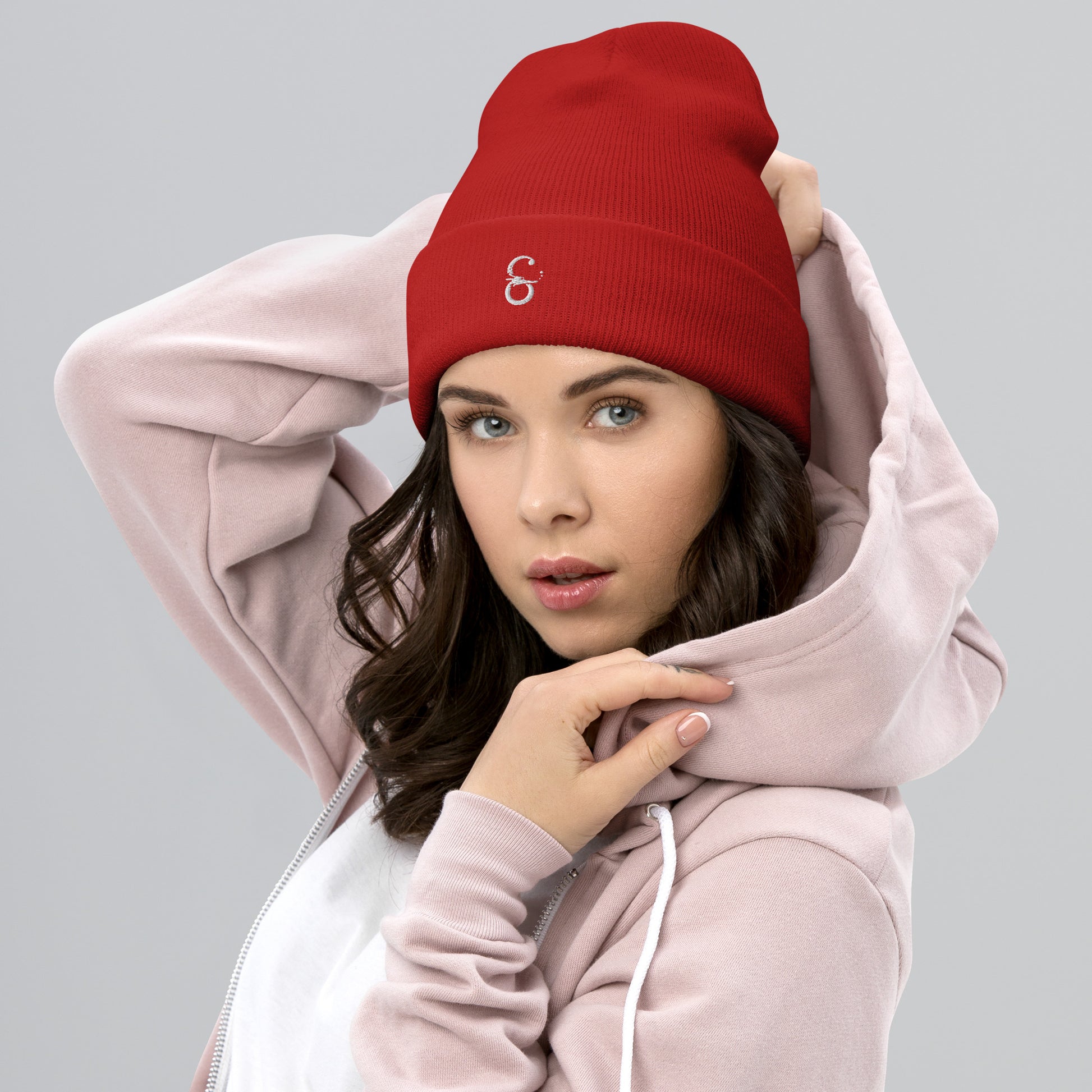 Gorro unisex de punto en color rojo, con el logo de Símera bordado al frente, modelo femenino mostrando el diseño.