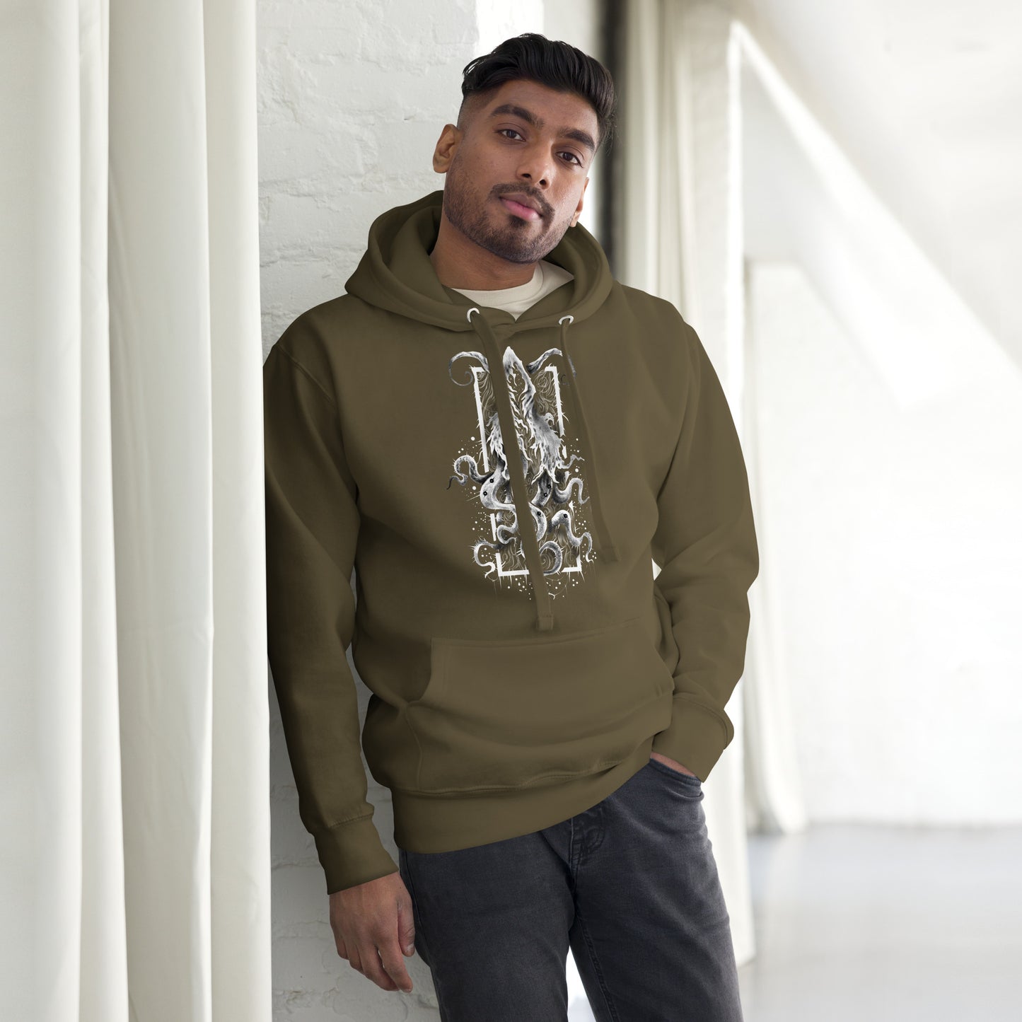 Modelo masculino usando la sudadera con capucha Dictador Cósmico en color verde militar, mostrando el diseño en el centro del pecho.